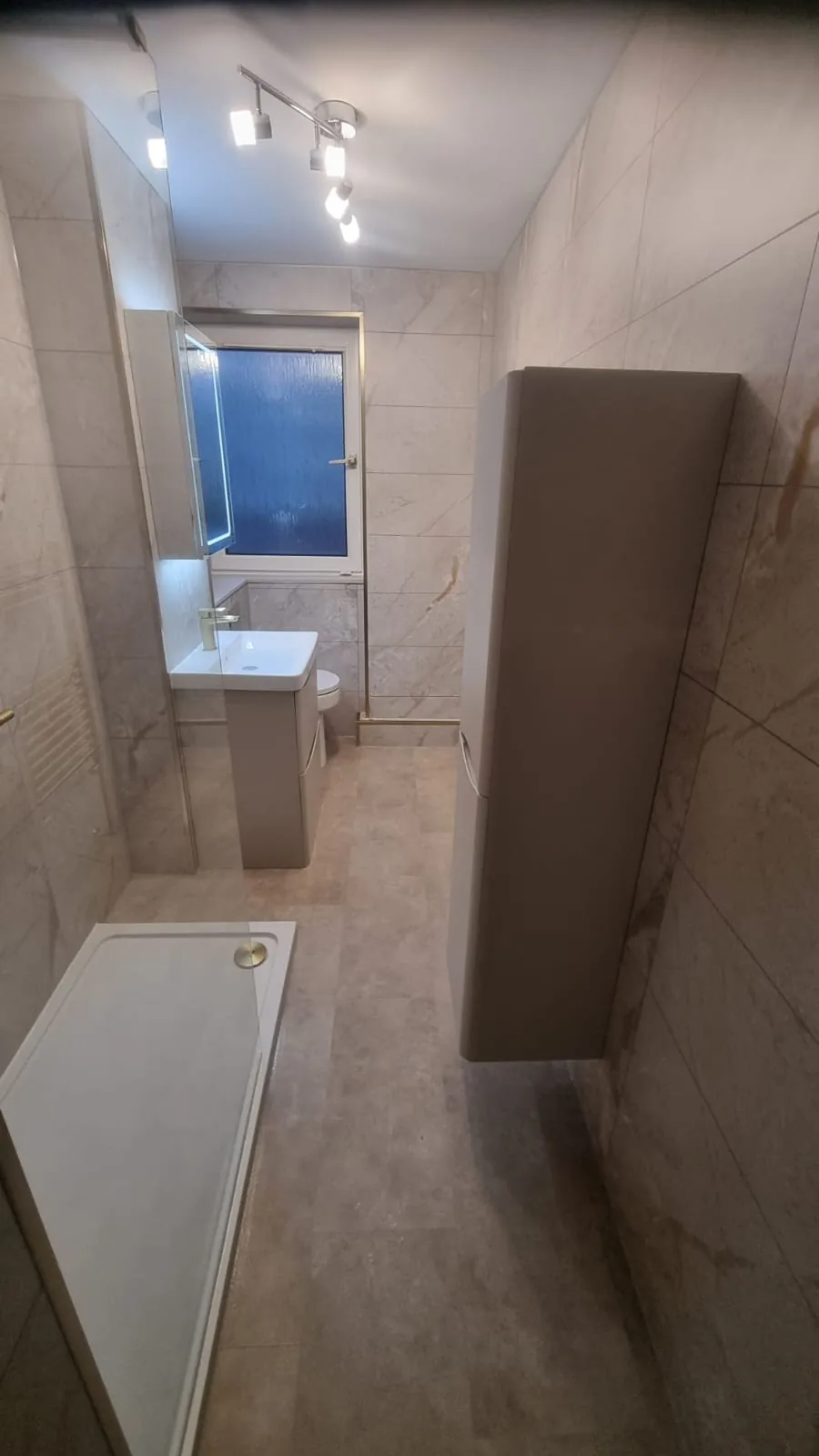 Narrow shower room with brass fittings and tall storage
