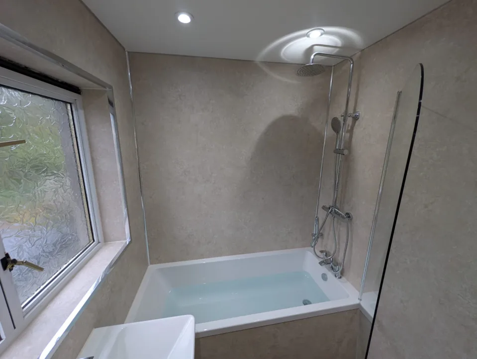 Shower over a white fitted bath with a clear screen